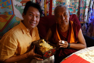 Fred Cheong is offering Rinpoche a medallion smaller than a nickel with 1,000 Namgyalma mantras on it. Photo: Ven. Roger Kunsang May 4, 2013.