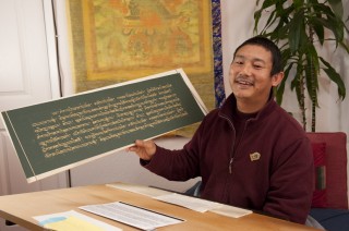 Ven. Tsering showing some of his work writing out the Prajnaparamita. Photo by Whitney Dafoe. 