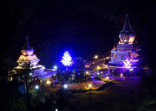 Kopan Monastery at Night, Khensur Rinpoche Lama Lhundrup's stupa to the left and Geshe Lama Konchog's stupa to the right and new light offerings on the trees, Nepal, December 2014. Photo by Ven. Roger Kunsang.