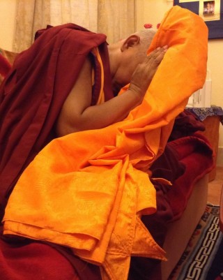 Lama Zopa Rinpoche blessing robes before they are offered to Buddha statue in Mahabodhi Temple, Bodhgaya. 