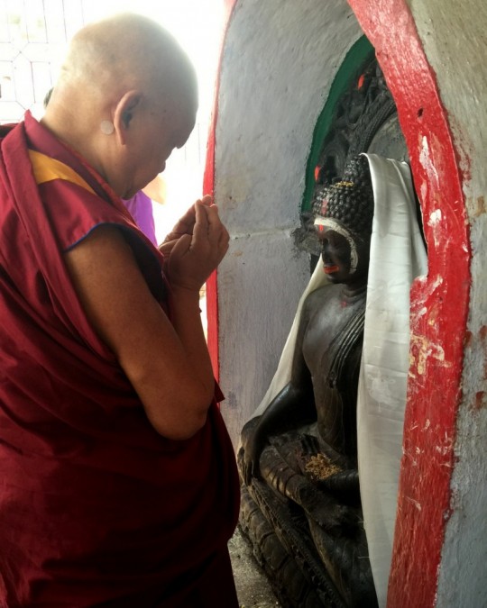 Lama Zopa Rinpoche praying in front of a statue of Buddha at Hindu holy place near Rajgir, India, March 2015. Photo by Ven. Roger Kunsang.