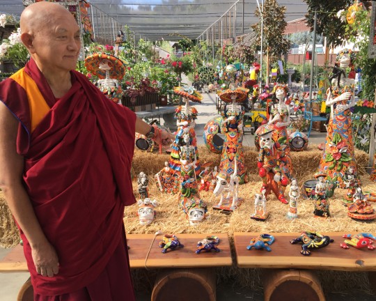 Lama Zopa Rinpoche taking interest in the Dia de los Muertos and Halloween decoration at a garden shop, California, October 2015. Photo by Ven. Roger Kunsang.