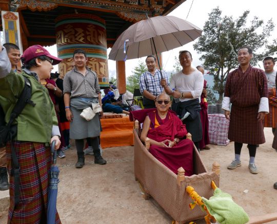 Lama Zopa Rinpoche and entourage stop for a short break two-thirds of the way along the trail to Tiger's Nest Monastery. It had just started to rain, Bhutan, May 2016. Photo by Ven. Roger Kunsang.