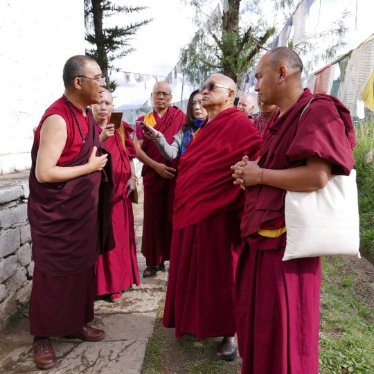 Lama Zopa Rinpoche listening to Khenpo Phuntsok Tashi as he describes the details of the holy site, Bhutan, May 2016. Photo by Ven. Roger Kunsang.