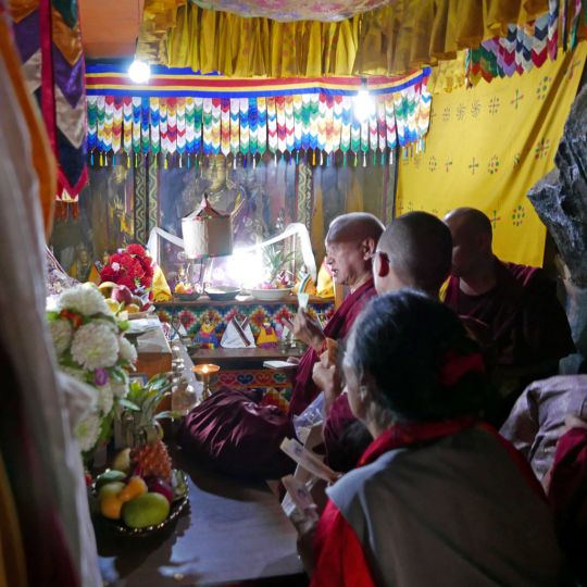 Lama Zopa Rinopche doing prayers in front of a Guru Rinpoche statue that is said to have spoke, inside the tiny gompa at the holy site of Guru Rinpoche's body, Paro, Bhutan, June 2016. Photo by Ven. Roger Kunsang.