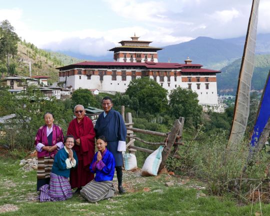 Lama Zopa Rinpoche with a  Bhutanese family in front of Rinpung Dzong, Bhutan, June 2016. Photo by Ven. Roger Kunsang. The mother of the family is Tibetan and took care of Rinpoche many years ago when he was a boy studying in Tibet.