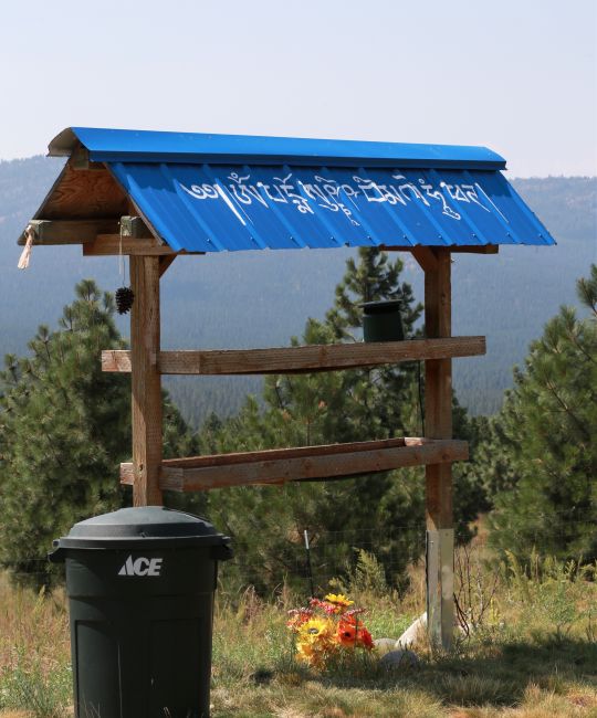 Bird feeder at Buddha Amitabha Pure Land with roof painted with a mantra to bless all the birds who go under it to eat. Washington State, 2014. Photo by Ven. Kunsang.