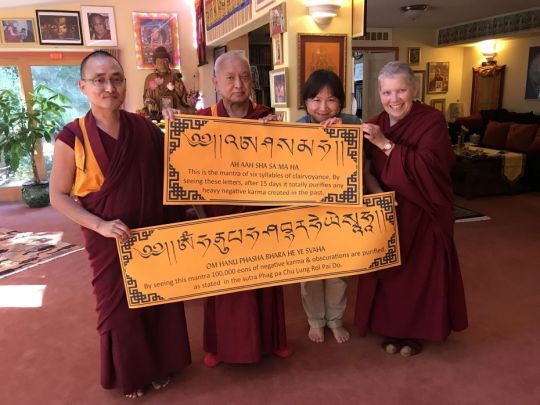 Lama Zopa Rinpoche with Ven. Lobsang Sherab, Monica Hung, and Ven. Carol Corradi with mantra posters, Aptos, California, US, June 2017. Photo by Ven. Roger Kunsang.