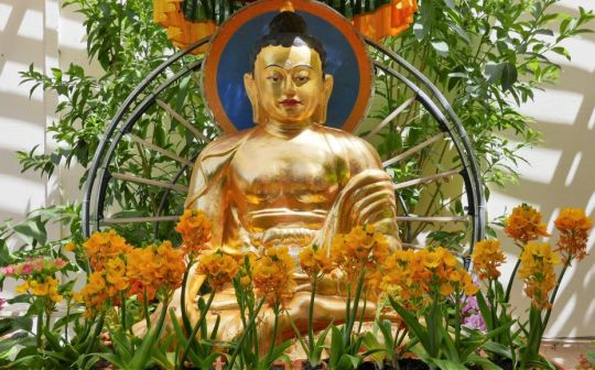 Statue of Buddha with flower offerings, Kachoe Dechen Ling, Aptos, California, US, August 2017. Photo by Ven. Roger Kunsang.