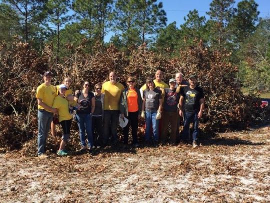 hurricane-florence-relief-work-volunteers-posing-for-a-group-photo-in-front-of-a-pile-of-cleared-branches-in-north-carolina-on-october-12-2018-photo-courtesy-of-kadampa-center