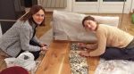 Lhagsam tibetan meditation study group members nina and jelena seated on the floor bending over a wood panel they are putting small grey stones onto to decorate it and make it a beautiful altar.