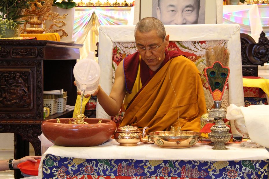 Khen Rinpoche Geshe Chonyi seated at the front of the Amitabha Buddhist Centre gompa making offerings