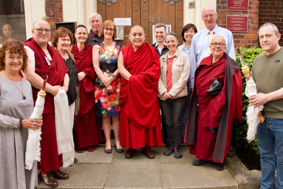 Ling Rinpoche standing outside of a door to Jamyang Buddhist Centre in London with a group of students who had just welcomed him to the center.