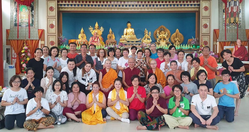 nyung na retreat participants gathered together posed for a photo in front of the altar in the rinchen jangsem ling gompa.