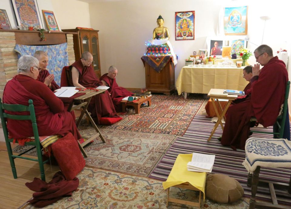Five western nuns seated in front of an altar engaged in practice together.