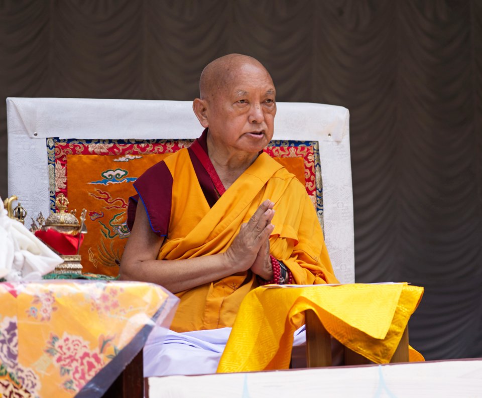Rinpoche on throne with hand in prostration mudra