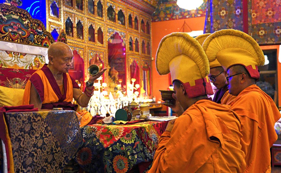 lama zopa rinpoche on throne being offered tsog