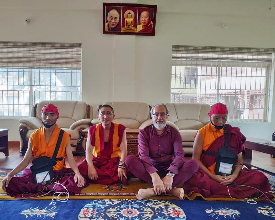 Three Tibetan monks and one Western scientist seated together