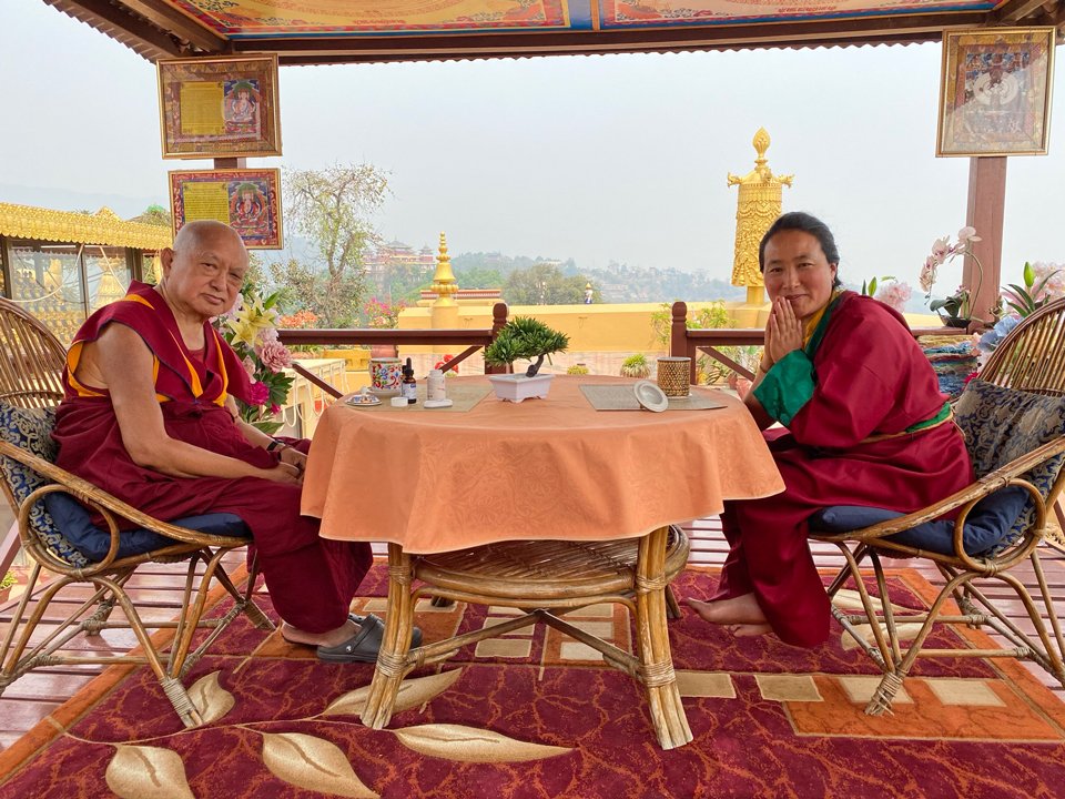Lama Zopa Rinpoche seated across a table from Khadro-la on the roof of Kopan Gompa