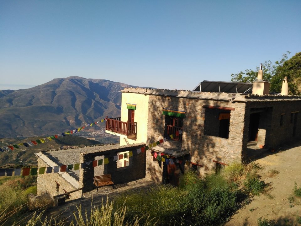 building with prayer flags and mountains in background