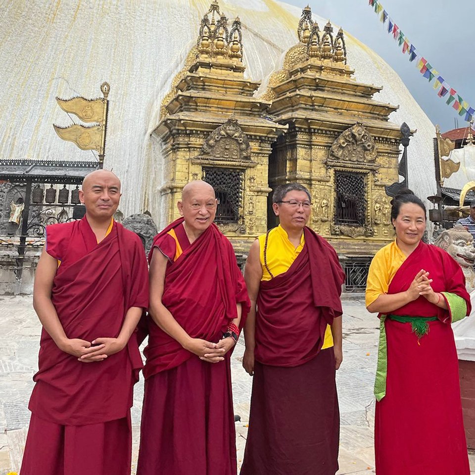 four lamas standing in front of Swayambu Stupa