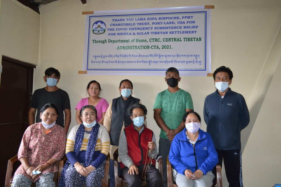 Tibetan refugees stand with thank you banner.