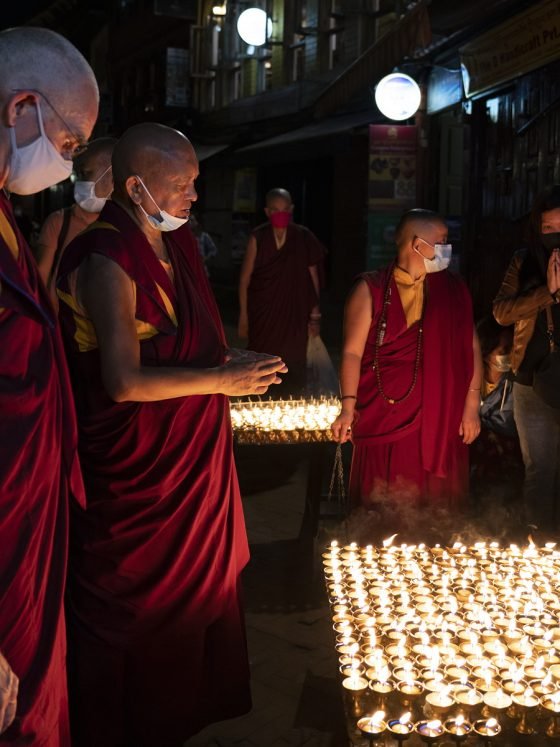 Lama Zopa Rinpoche praying over hundreds of butter lamp offerings at night