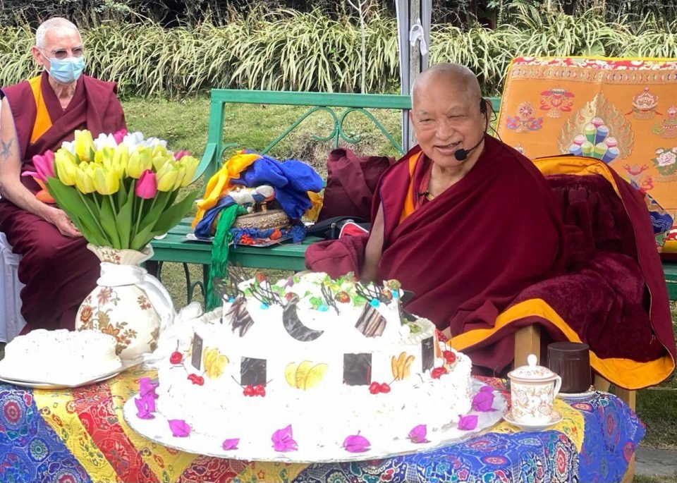 Lama Zopa Rinpoche with a large decoracted cake in front of him