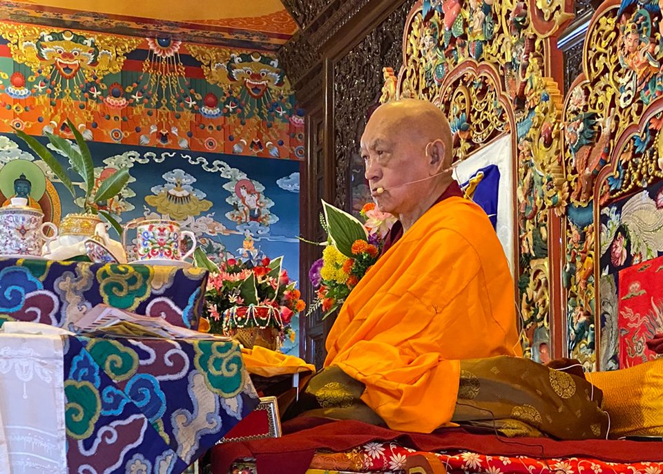 Lama Zopa Rinpoche sitting on a teaching thrown 
