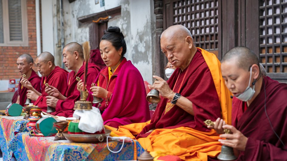 Lama Zopa Rinpoche, Khadro-la, and four other ordained Sangha sit at puja tables outside and do puja