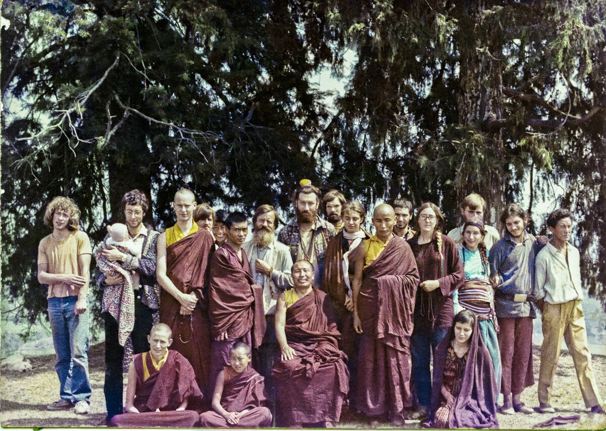 Second Kopan Meditation Course, spring of 1972. Included in the photo are Ann McNeil (Anila Ann), Mark Shaneman (Jhampa Zangpo), Steve Malasky, Gen Wangyal, Åge Delbanco (Babaji), Peter Kedge, Geshe Thubten Tashi (seated in middle), Losang Nyima, Chris Kolb (Ngawang Chötak), Ron Brooks and Massimo Corona with the newborn baby Maitri.
