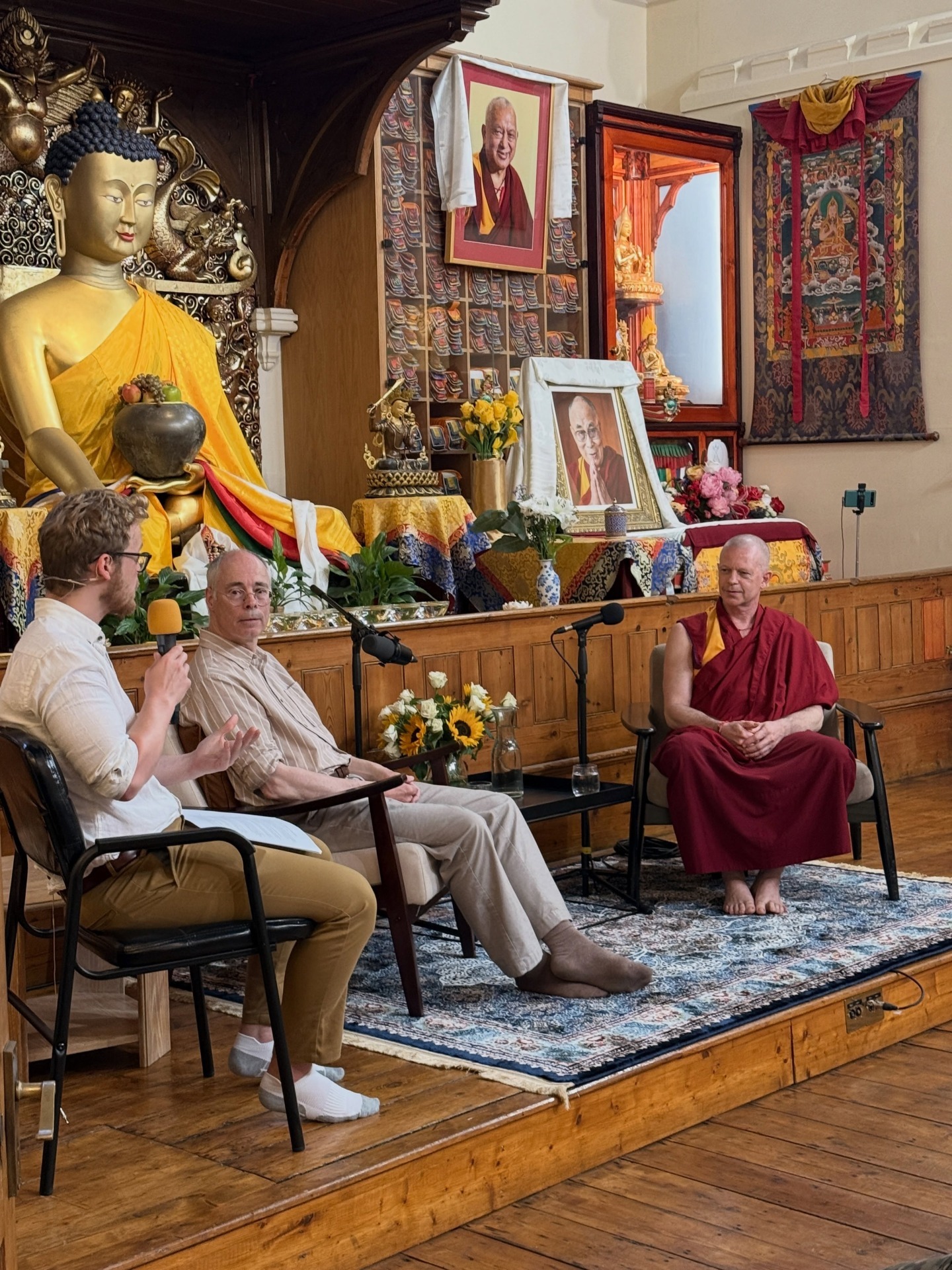 Chris Scammel moderating Geshe Tenzin Namdak, in conversation with Professor Murray Shanahan. JBC London, June 2026. Photo by JBC