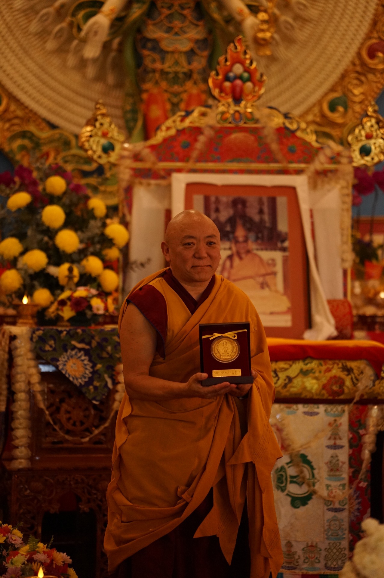 Geshe Phuntsok Tsultrim with a gold Chenrezig memento during the consacration of Chenrezig statue. July 11, 2026, Chenrezig Institute. Photo courtesy of CI