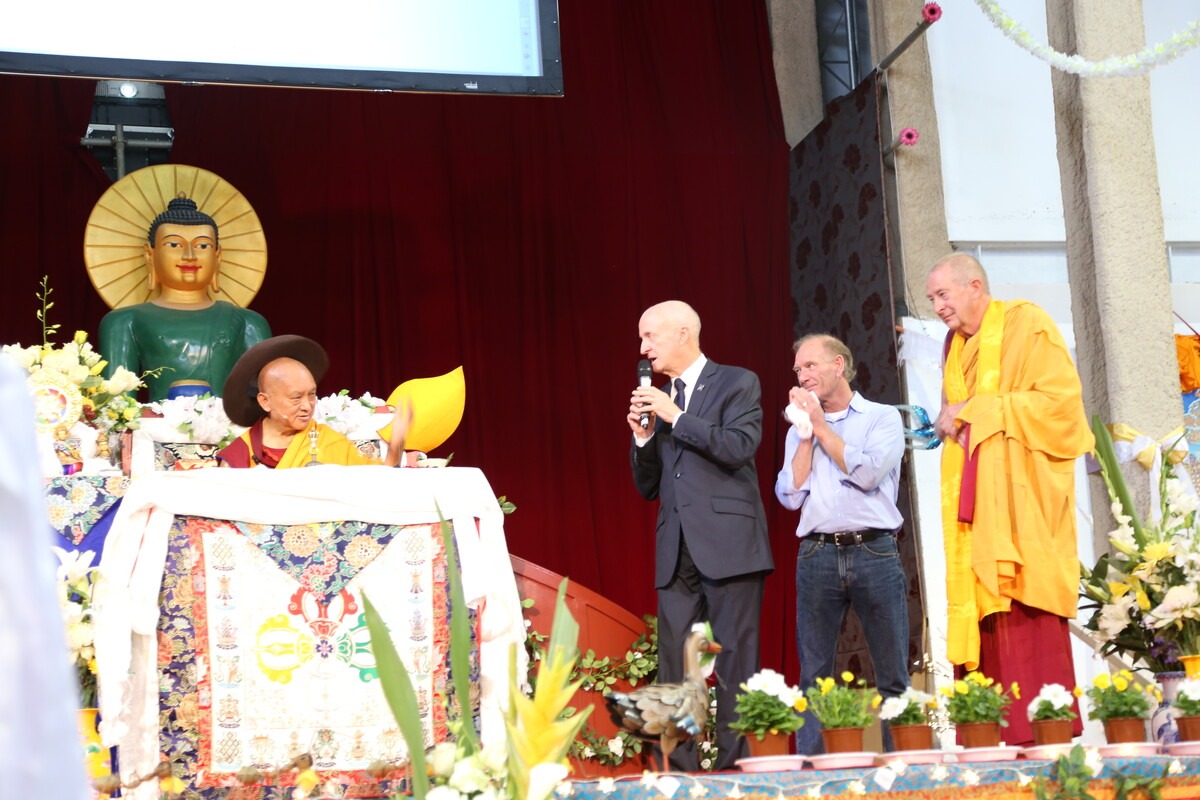 Jade Buddha behind Lama Zopa Rinpoche, with Ian Green, Liam, and Ven. Gyatso, Australia, 2014. Photo by Thubten Kunsang (Henri Lopez).