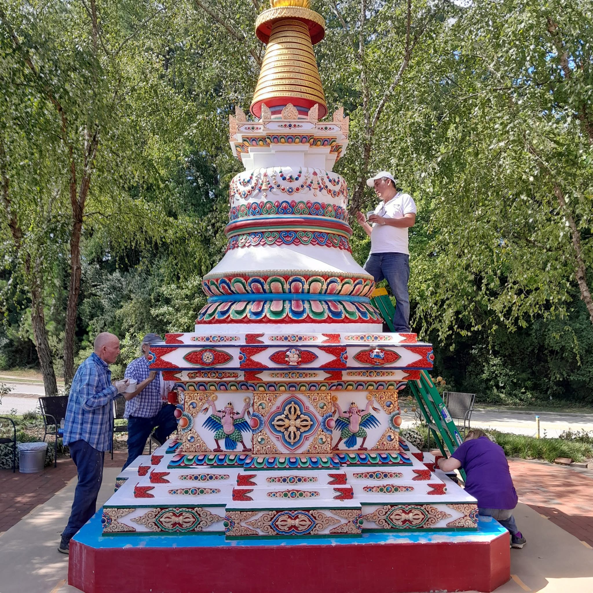 Volunteers repaint the stupa under the guidance of artist Jampal Hyolmo at Kadampa Center. Photo courtesy of Kadampa Center’s Facebook page.