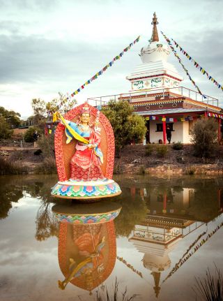 Padmasambhava statue and stupa with reflections on a very still pond. Photo by George Manos.