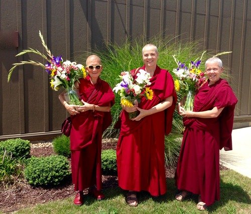 three nuns holding flowers