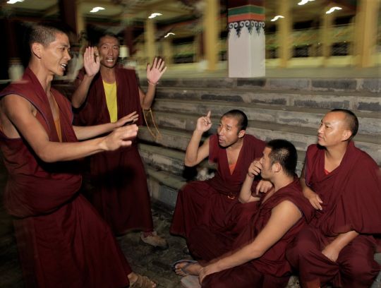 Tibetan monks at Sera argue a point during a night-time debate. (L to R) Vens. Ngawang Gyatso, Losang Nyima, Losang Gyatso, Losang Trinley, and one unknown, Sera Je Monastery, India, November 2013. Photo by Sandesh Kadur.