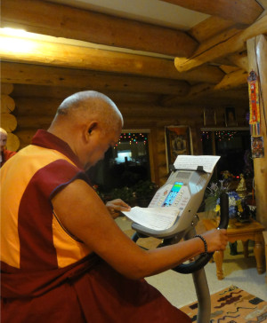 Lama Zopa Rinpoche reading texts while on his exercise bike, US.