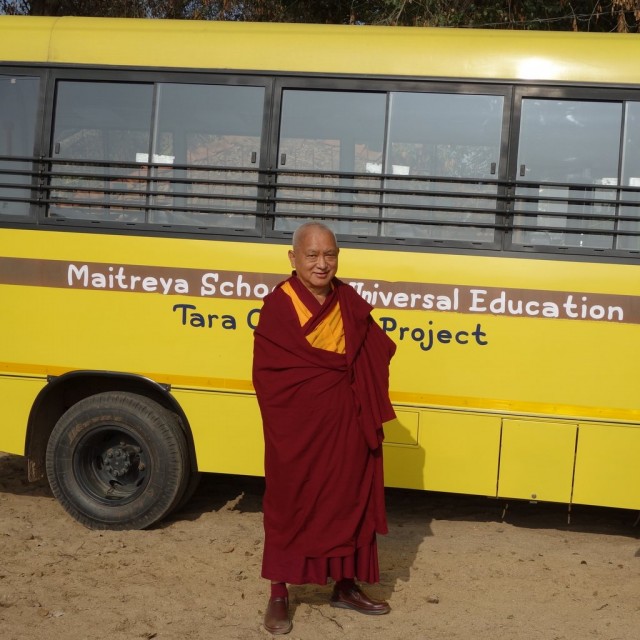 Lama Zopa Rinoche in front of the new bus that serves children attending the Maitreya School and who are part of the Tara Children's Project, January 2014. Photo by Ven. Roger Kunsang.