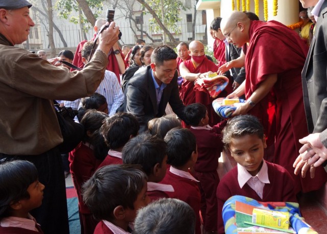 His Holiness the Karmapa offers gifts to Maitreya School children, Bodhgaya, India, January 31, 2014. Photo by Ven. Roger Kunsang.