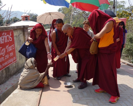Lama Zopa Rinpoche  visiting Rajgir and offering to the beggars on the way up to Vulture's Peak, India, March 2014. Photo by Ven. Roger Kunsang.