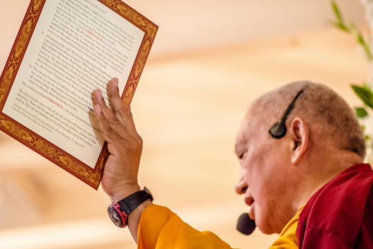 Lama Zopa Rinpoche with the card "Compassion is of the Utmost Need," created by FPMT Education Services, Land of Medicine Buddha, California, September 2013. Photo by Chris Majors.