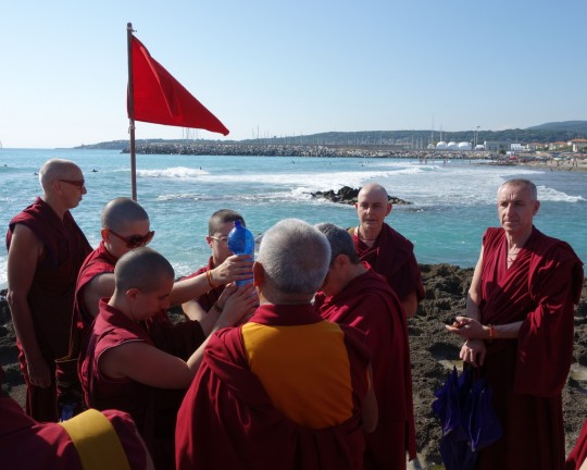 Lama Zopa Rinpoche with Sangha at the beach doing offerings to pretas, Italy, June 2014. Photo by Ven. Roger Kunsang.