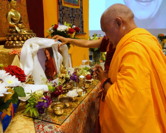 Lama Zopa Rinpoche offering a khata to a photo of His Holiness the Dalai Lama on His Holiness' birthday, Jamyang Buddhist Centre Leeds, UK, July 6, 2014. Photo by Ven. Roger Kunsang.