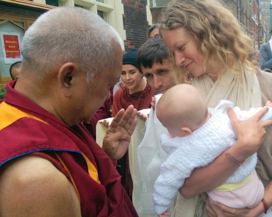 Lama Zopa Rinpoche blessing a baby upon arriving at Jamyang Buddhist Centre, London, UK, July 2014. Photo by Ven. Roger Kunsang.
