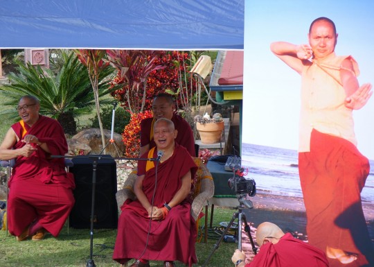 Lama Zopa Rinpoche with Geshe Jamyang and Geshe Phuntsok (resident geshe at Chenrezig Institute) next to a life-sized poster of Lama Yeshe during Chenrezig Institutes 40th anniversary celebration, Australia, September 2014. Photo by Ven. Roger Kunsang.