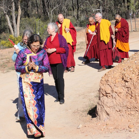 Lama Zopa Rinpoche being led to the long life puja in the Great Stupa of Universal Compassion by (from right) Khen Rinpche Geshe Chonyi, FPMT CEO Ven. Roger Kunsang, Thubten Shedrup Ling director Gyatso, FPMT Board of Directors secretary Paula de Wys,  FPMT Australia coordinator Helen Patrin and FPMT Center Cervices director Claire Isitt, Australia, September 19, 2014. Photo by Laura Miller.