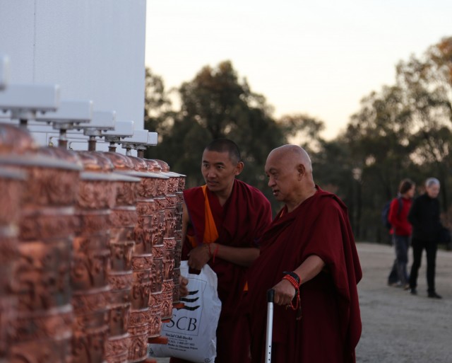 Lama Zopa Rinpoche turning the prayer wheels outside the Great Stupa at dusk, Australia, September 12, 2014. Photo by Ven. Thubten Kunsang