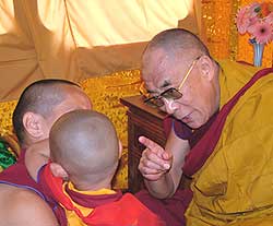 Tulku Tenzin Phuntsok Rinpoche having his hair cut by His Holiness  the Dalia Lama during the Kalachakra event. Photographer Ven Roger Kunsang